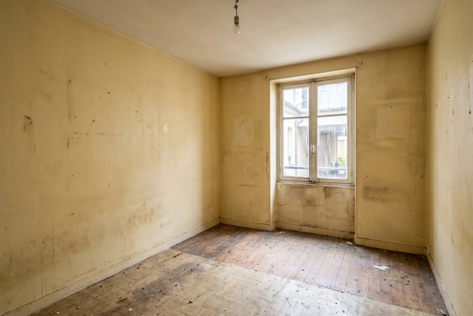 Studio vide aux murs jaunis, avant la remise en état
