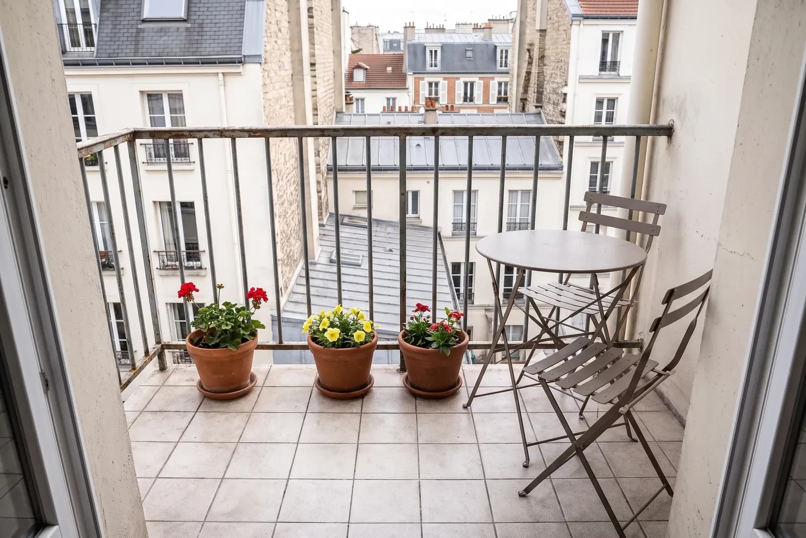 Le même balcon balayé, avec une table et des plantes, après le home staging