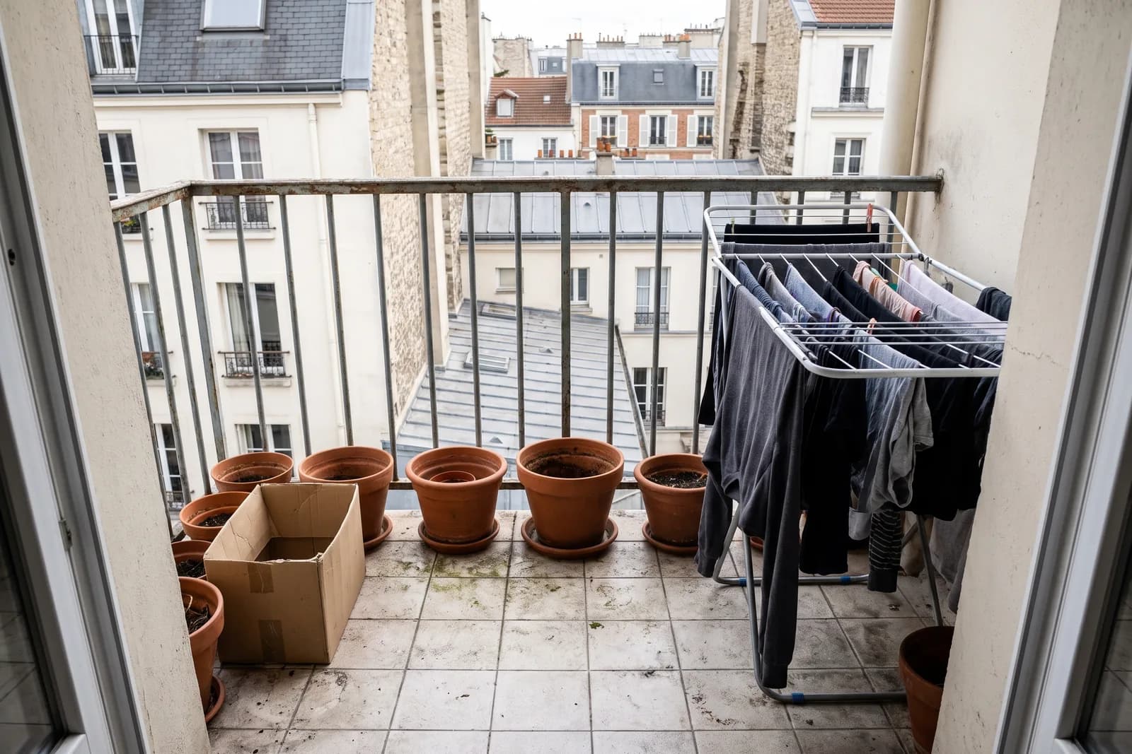 Balcon encombré d'un étendoir et de cartons, avant le home staging