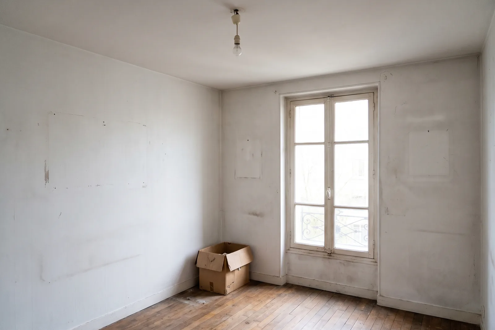 Pièce vide aux murs marqués, avant la remise en état